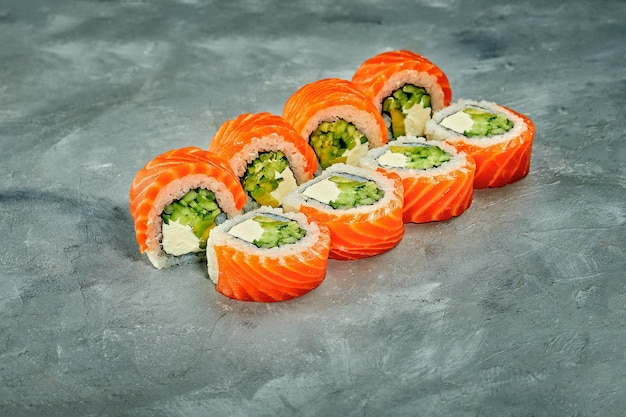 Sushi-Rolle mit Lachs, Gurke und Frischkäse auf grauem Hintergrund Selektiver Fokus Sushi-Menü