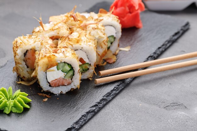 Sushi-Rolle mit Thunfischspänen auf Teller nah oben