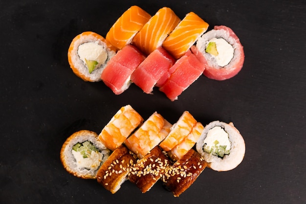 Sushi-Rollen auf dunklem Hintergrund Japanisches und asiatisches Lebensmittelkonzept