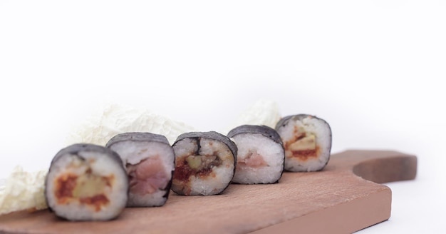 Sushi-Rollen auf einem Schneidebrett isoliert auf weiß