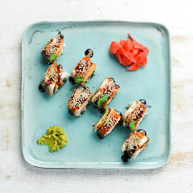 Sushi-Rollen mit Aal, Wasabi und Sojasauce. Japanisches Essen. Ansicht von oben. Rustikaler Stil.