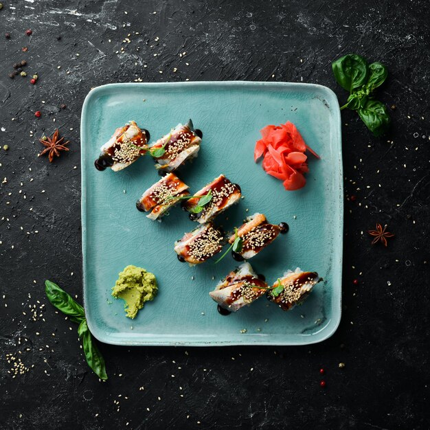 Sushi-Rollen mit Aal, Wasabi und Sojasauce. Japanisches Essen. Ansicht von oben. Rustikaler Stil.
