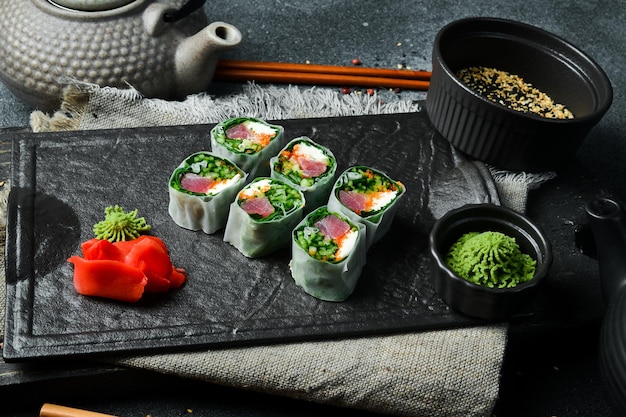 Sushi-Rollen mit Kohl, Thunfisch und Avocado mit Wasabi-Sauce und eingelegtem Ingwer