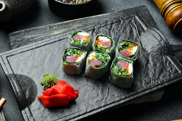 Sushi-Rollen mit Kohl, Thunfisch und Avocado mit Wasabi-Sauce und eingelegtem Ingwer