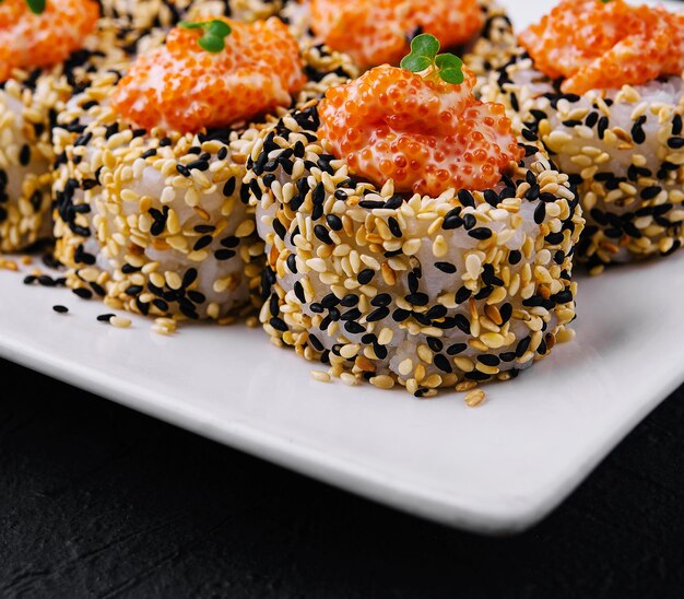 Sushi-Rollen mit Lachsstücken und rotem Kaviar