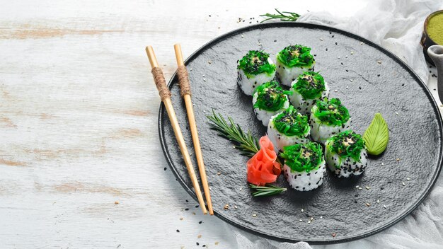 Sushi-Rollen mit Meeresfrüchten und Chuka-Salat Grünes Sushi Draufsicht Freier Platz für Ihren Text