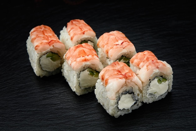 Sushi-Rollen Philadelphia mit Schneekrabben-Frischkäse-Gurken-Sesamsamen auf schwarzem Hintergrund isoliert Japanische orientalische Küche