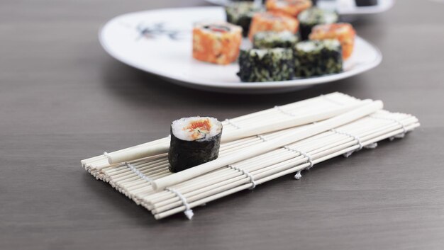 Sushi-Rollen und Stäbchen auf einem Holztisch