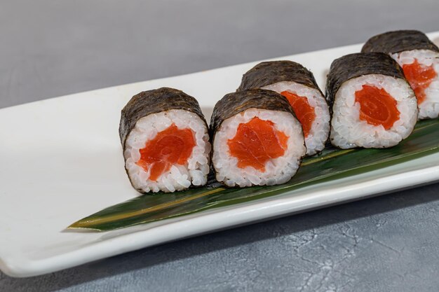 Foto sushi y rollos con camarón de caviar y aguacate de atún sobre un fondo gris