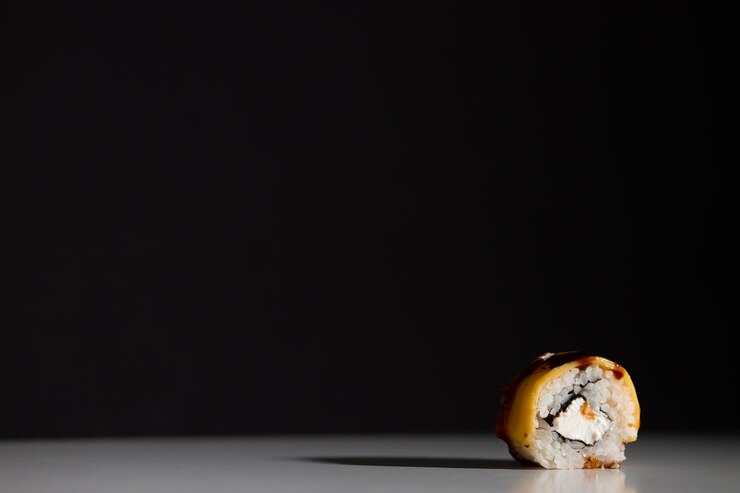 Sushi y rollos con diferentes rellenos sobre un fondo negro