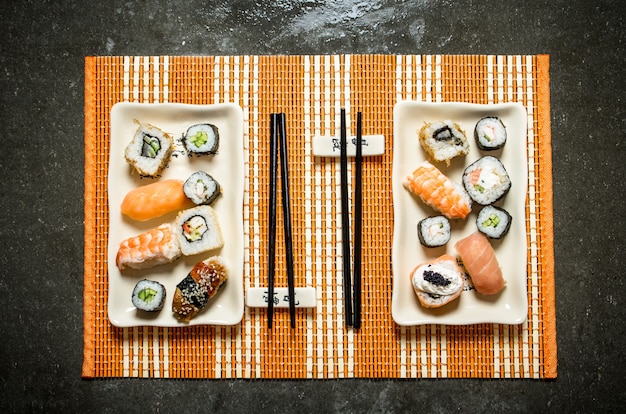 Sushi y rollos con mariscos en un soporte de bambú.