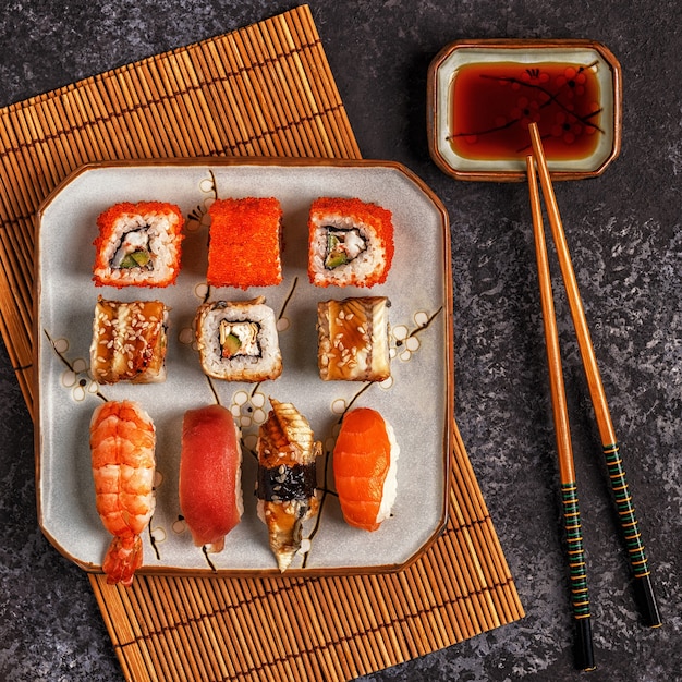 Sushi y rollos de sushi en plato con palillos