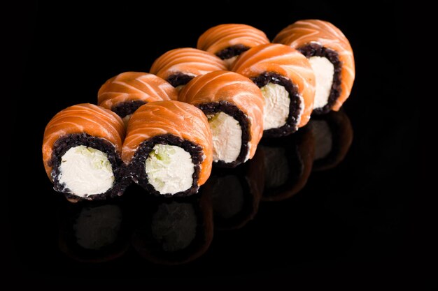 Sushi rollt Sushi auf schwarzem Hintergrund Muscheln