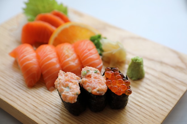 Sushi de salmón y sashimi en placa de madera comida japonesa