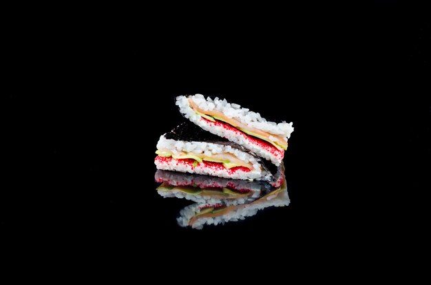 Sushi-Sandwich mit Lachs reflektiert auf schwarzem Hintergrund