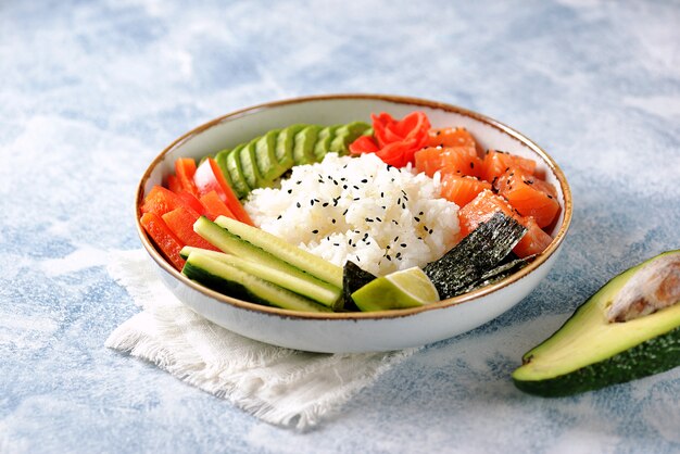 Sushi-Schüssel mit Reis, Lachs, Avocado, Gurke und Sesam