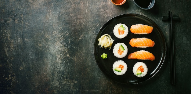 Sushi servido en el plato en la mesa oscura