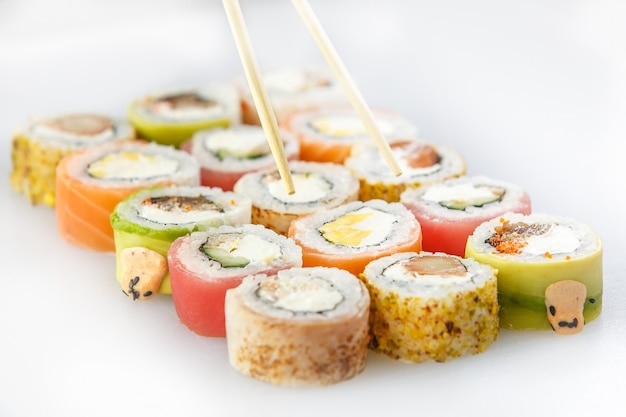 Sushi-Set. Brötchen mit Lachs und Gemüse, vegetarisch, auf einer Holzplatte isoliert auf weißer Oberfläche