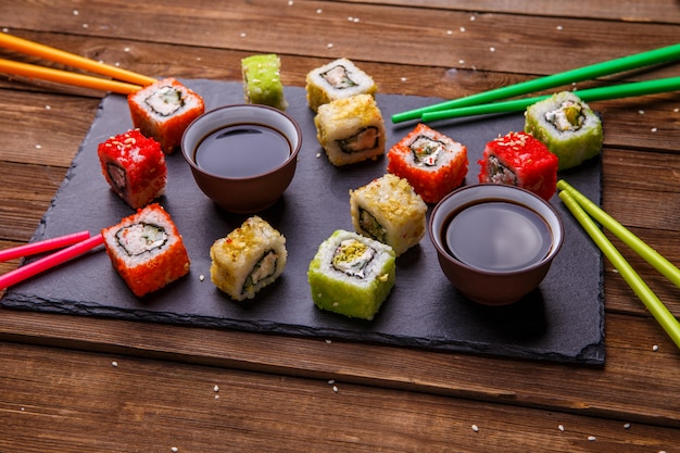 Sushi Set Brötchen mit Sojasauce serviert auf grauem Schiefer