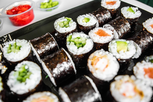 Sushi set closeup sobre fondo negro Mariscos japoneses tradicionales Delicioso rollo Anuncio