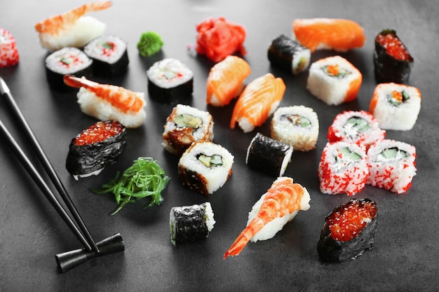 Sushi-Set und Stäbchen auf dunklem Hintergrund