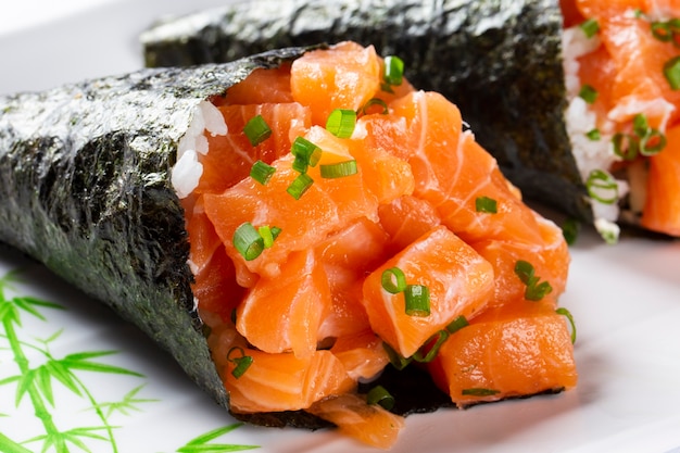 Foto sushi temaki de salmão em prato branco em prato branco