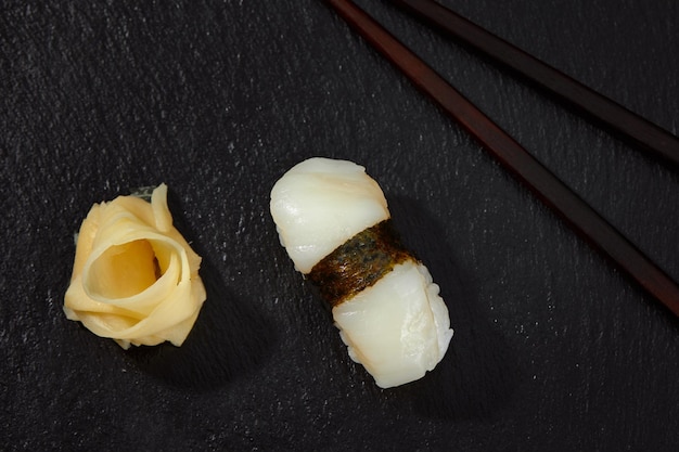 Sushi tradicional japonés con calamares sobre fondo negro Auténtica comida japonesa