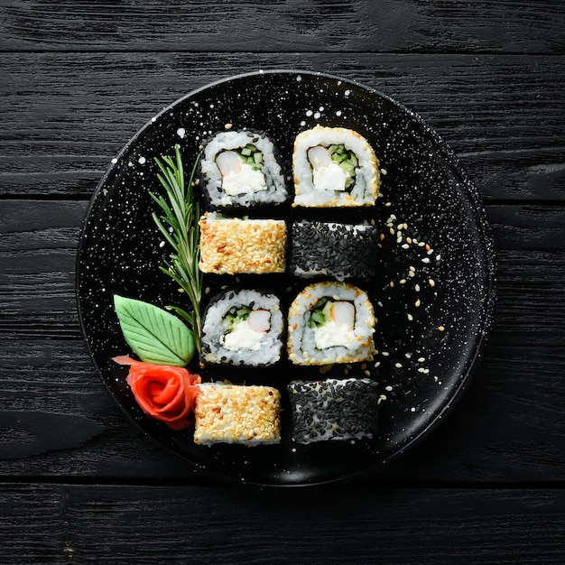 Sushi tradicional preto e branco com queijo de caranguejo e ervas cozinha japonesa Vista superior