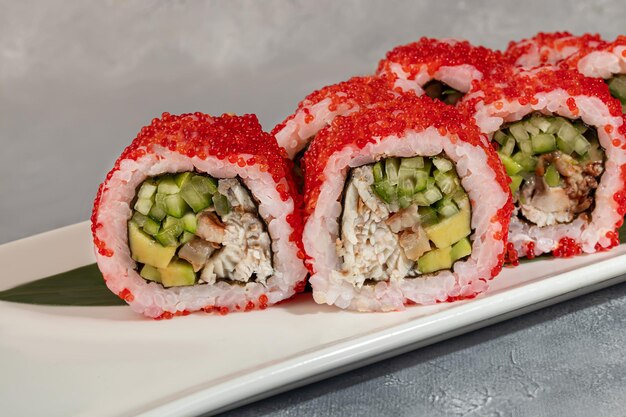 Sushi und Brötchen mit Kaviar, Garnelen und Thunfisch-Avocado auf einem grauen Hintergrund