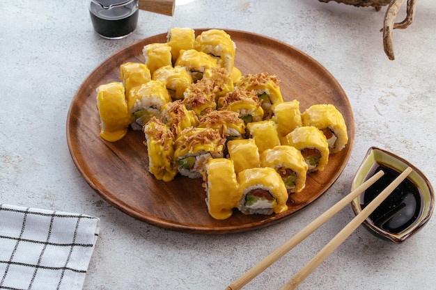 Sushi und Sojasauce in einer Schüssel und hölzerne Essstäbchen auf einem grauen Holztisch Japanisches Essen Sushi-Set Auswahl an Brötchenmenü