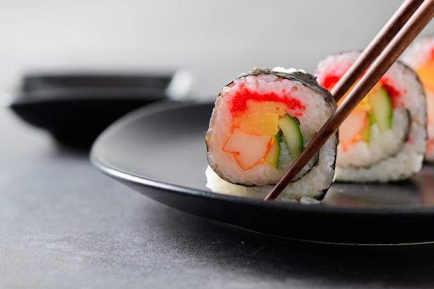 Sushirollen (gemüse-, inari- und krabbenstangen) mit essstäbchen