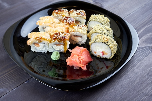 Sushirollen mit Ingwer und Wasabi auf einem Schwarzblech