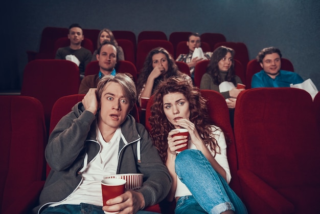 Suspense de observação dos pares novos amedrontados no cinema.