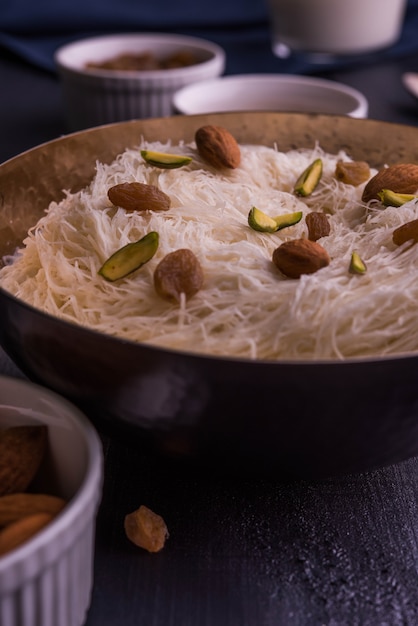 Sutarfeni doce indiano ou sutar feni ou firni ou seviyan ou laccha, ralado, farinha de arroz em flocos torrado em ghee, misturado com açúcar derretido para formar um algodão doce, coberto com pistache e amêndoas