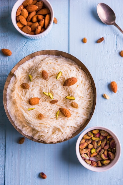 Sutarfeni dulce indio o sutar feni o firni o seviyan o laccha, rallado, harina de arroz en hojuelas tostado en ghee, mezclado con azúcar derretido para formar un algodón de azúcar, cubierto con pistacho y almendras