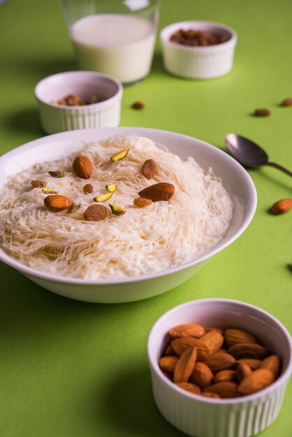 Sutarfeni dulce indio o sutar feni o firni o seviyan o laccha, rallado, harina de arroz en hojuelas tostado en ghee, mezclado con azúcar derretido para formar un algodón de azúcar, cubierto con pistacho y almendras