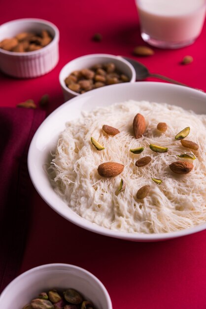 Sutarfeni dulce indio o sutar feni o firni o seviyan o laccha, rallado, harina de arroz en hojuelas tostado en ghee, mezclado con azúcar derretido para formar un algodón de azúcar, cubierto con pistacho y almendras