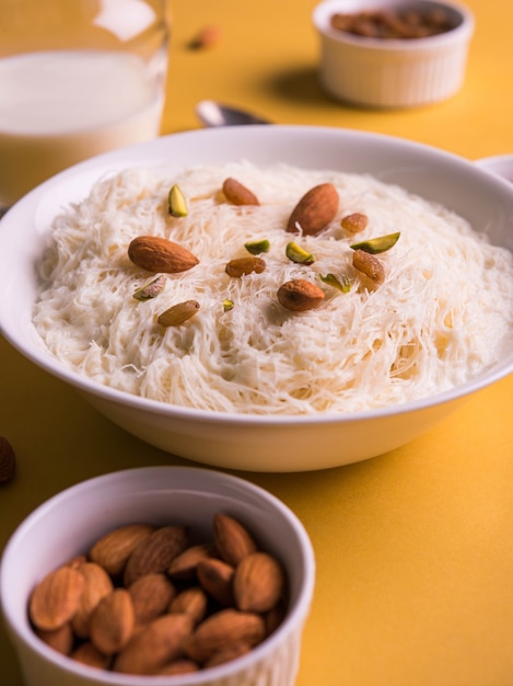 Sutarfeni dulce indio o sutar feni o firni o seviyan o laccha, rallado, harina de arroz en hojuelas tostado en ghee, mezclado con azúcar derretido para formar un algodón de azúcar, cubierto con pistacho y almendras