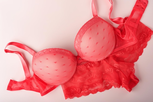 Sutiã sexy vermelho e calcinha em fundo rosa Roupa íntima feminina sexy com rosas e perfume Ideia de presente para o dia das mulheres ou dia dos namorados com espaço de cópia Surpresa para homens ou para ele Vista superior