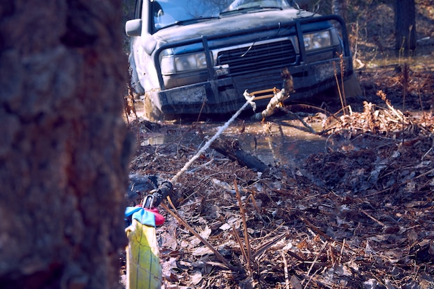 SUV 4x4 se saca de la trampa con un cabrestante atrapado en un árbol. Carreras todoterreno extremas