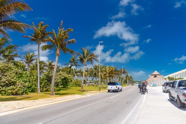 SUV conduciendo por la carretera con palmeras en un día soleado cerca de Cancún México