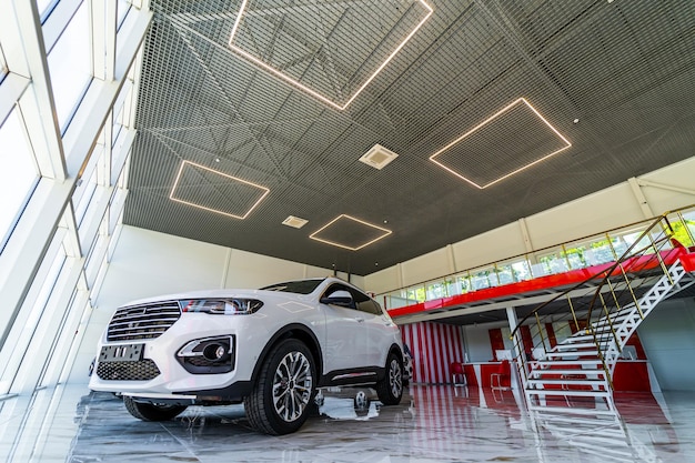 Suv de lujo blanco se encuentra en la sala de exposición del concesionario de automóviles Venta de automóviles de marca en el centro especial Primer plano