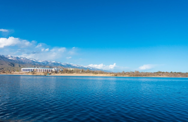 Sverny orilla del lago IssykKul Kirguistán Vista desde el barco hasta la orilla Agua azul de un lago de montaña