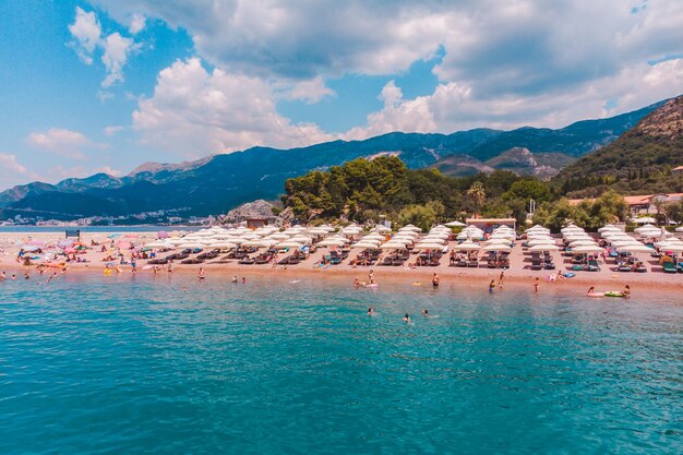 SVETI STEFAN MONTENEGRO 18 de julio de 2018 verano personas en playa rocosa sombrillas y tumbonas