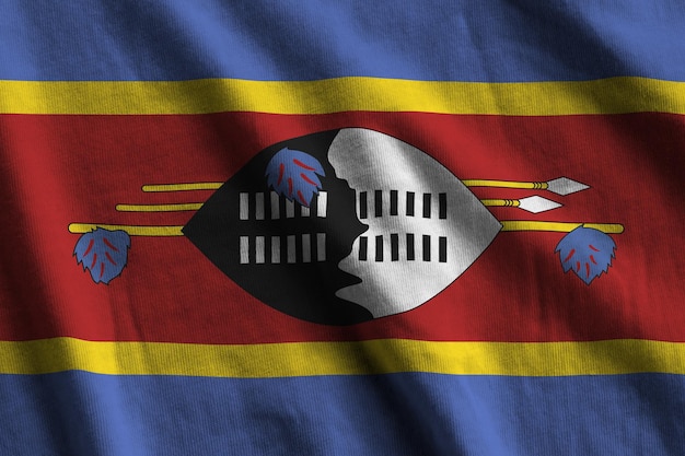 Swasiland-Flagge mit großen Falten, die in der Nähe unter dem Studiolicht im Innenbereich die offiziellen Symbole wehen