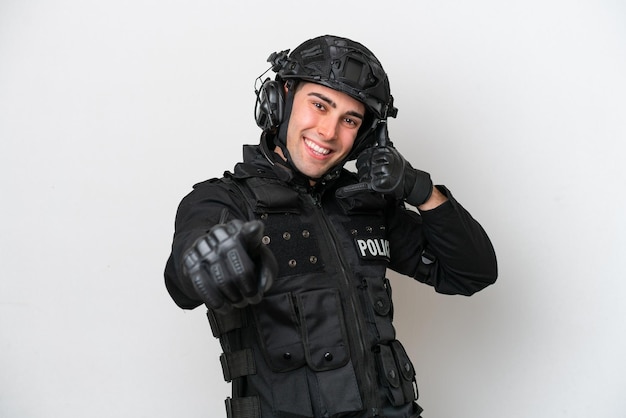 SWAT hombre caucásico aislado sobre fondo blanco haciendo gestos de teléfono y apuntando hacia el frente