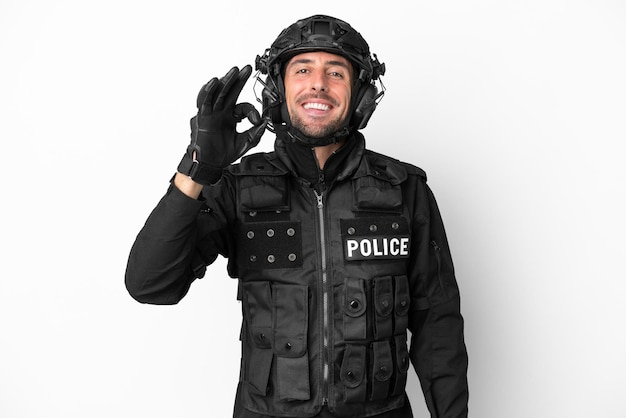 SWAT homem caucasiano isolado no fundo branco, mostrando sinal de ok com os dedos