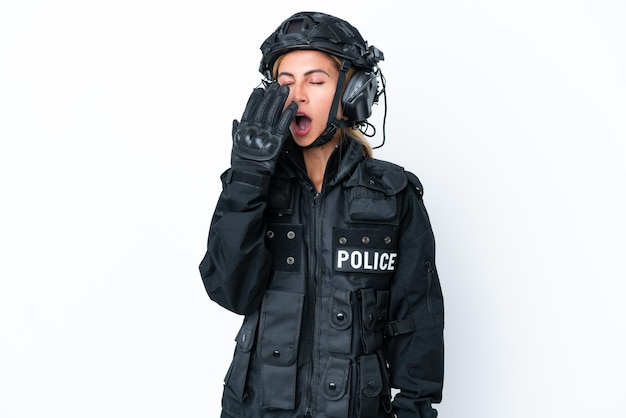 SWAT mujer caucásica aislada sobre fondo blanco bostezando y cubriendo la boca abierta con la mano