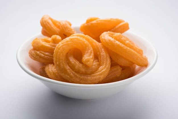 Sweet Paneer Jalebi serviert in einer Keramikplatte über buntem oder hölzernem Hintergrund. Selektiver Fokus