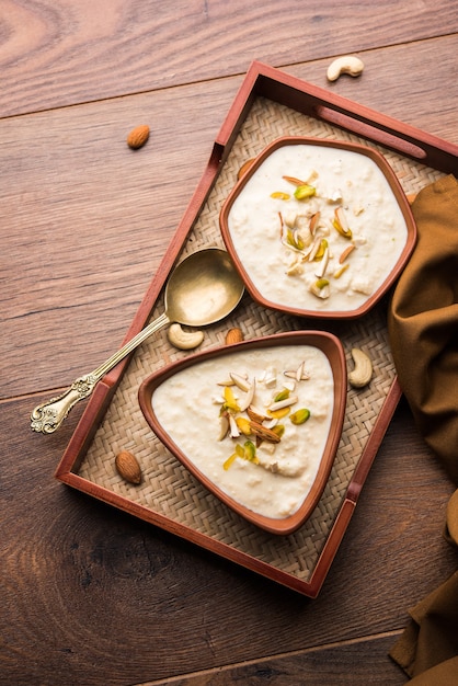 Sweet Rabdi ou Lachha Rabri ou basundi, feito com leite puro decorado com frutas secas. Servido em uma tigela sobre um fundo mal-humorado. Foco seletivo